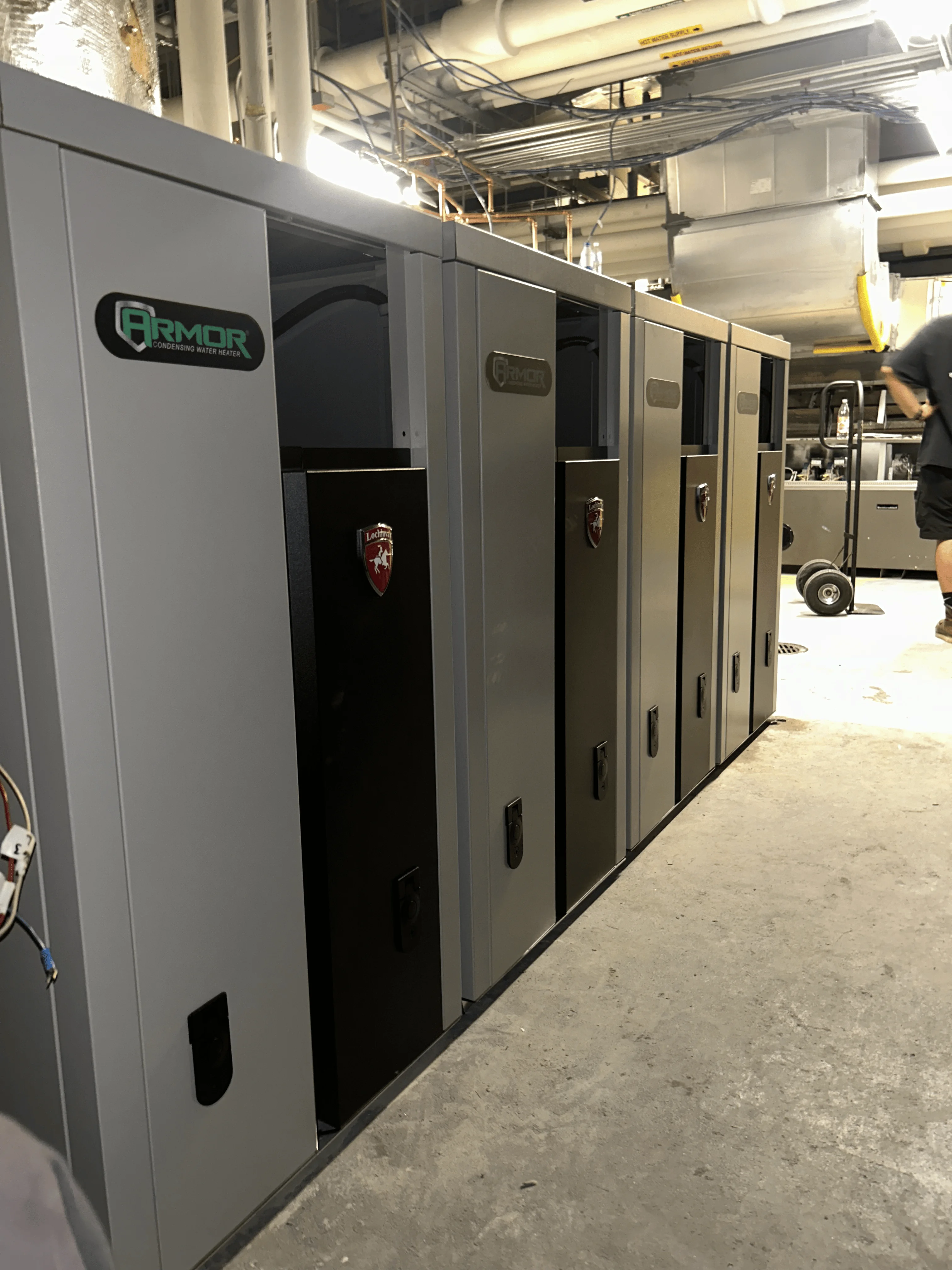 Row of gray and black commercial HVAC units installed in industrial mechanical room